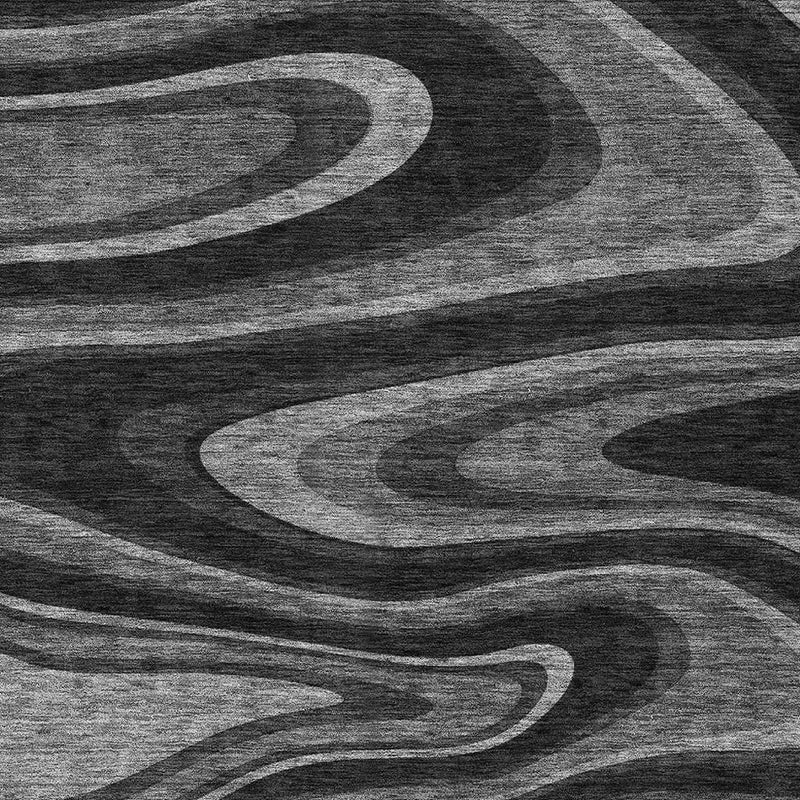 Detailed view of black and gray abstract area rug with textured look and wavy stripe pattern.