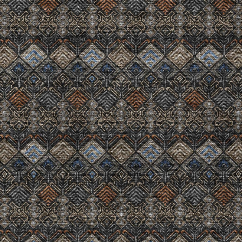 Close-up geometric rug pattern in charcoal with tan, blue, and rust diamond motifs