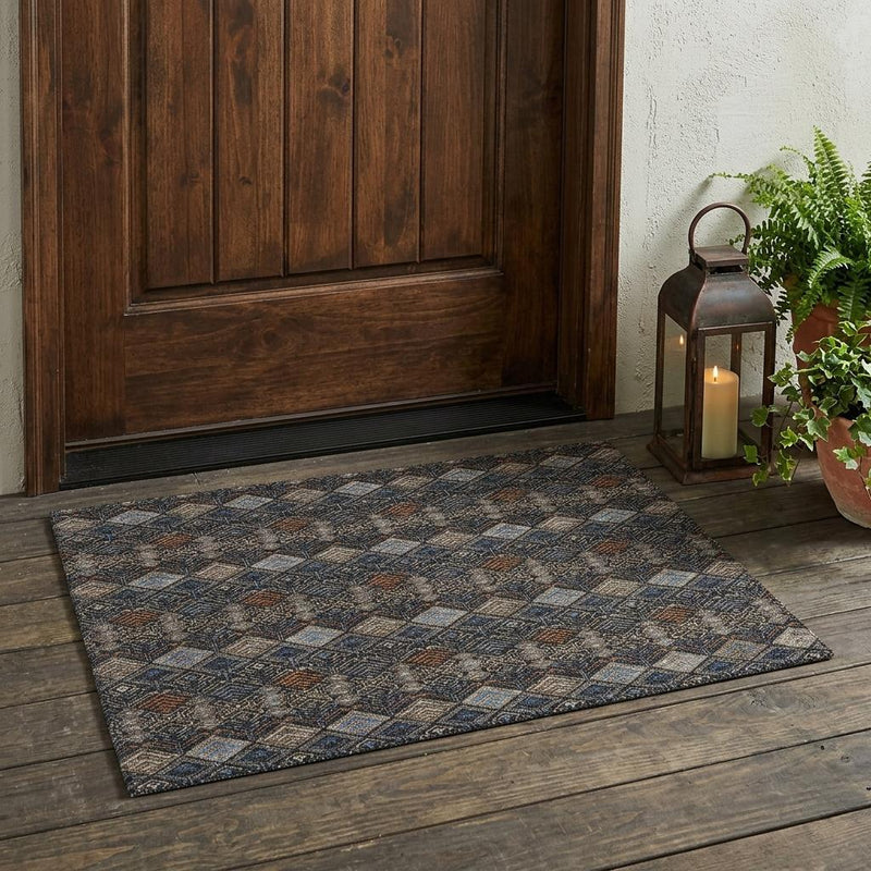 Geometric washable area rug with dark charcoal base and blue, tan, and rust pattern