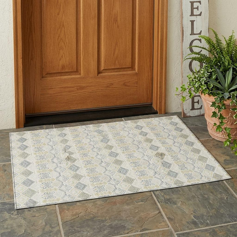 Indoor outdoor area rug laid on floor, ivory field with blue and wheat geometric pattern