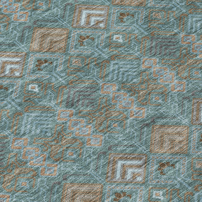 Close-up of teal geometric area rug with diamond and square motif texture