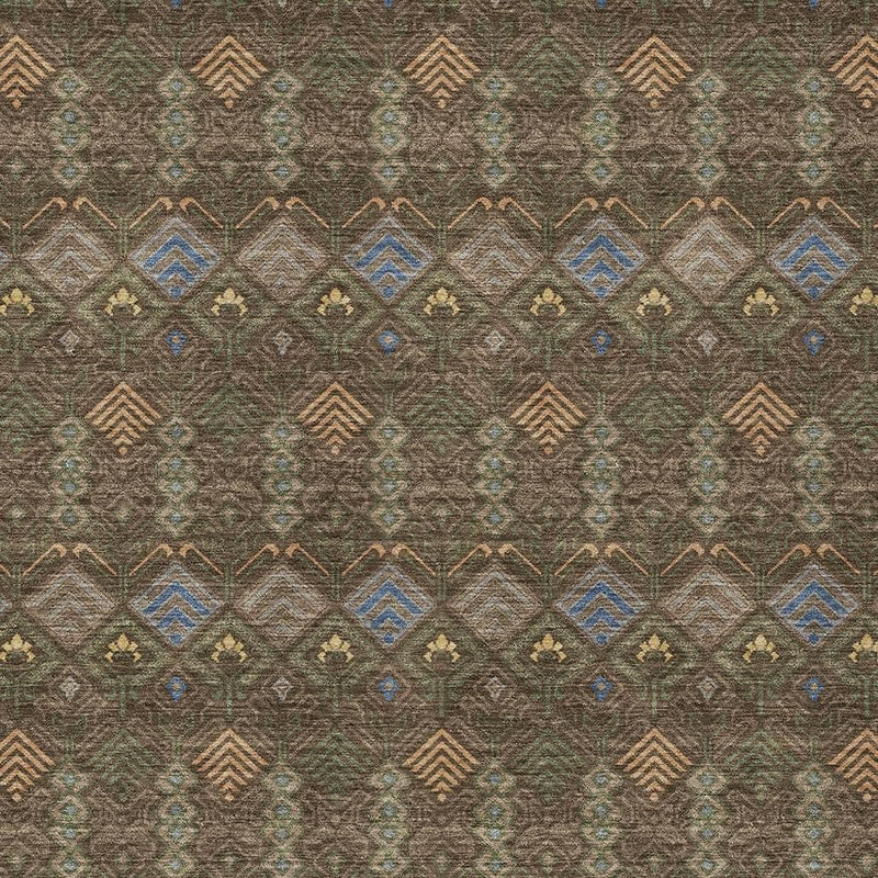 Geometric area rug close-up with blue, tan, and rust diamonds on dark green-brown