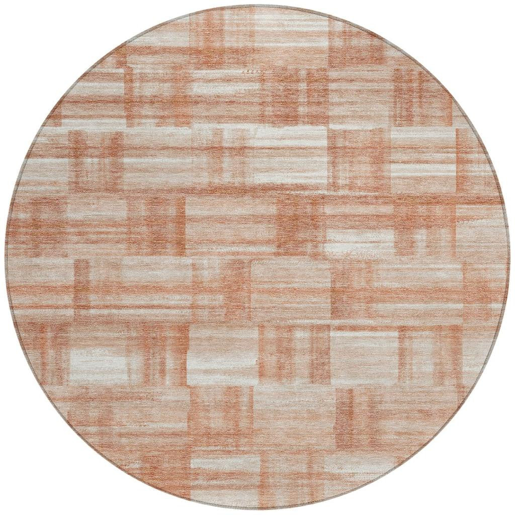 Round area rug with cream background and salmon-copper rectangular stripe pattern