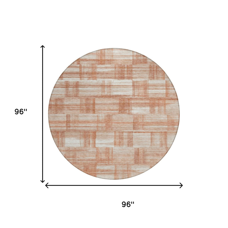 Round area rug with cream and salmon rectangle pattern and rust-copper edging