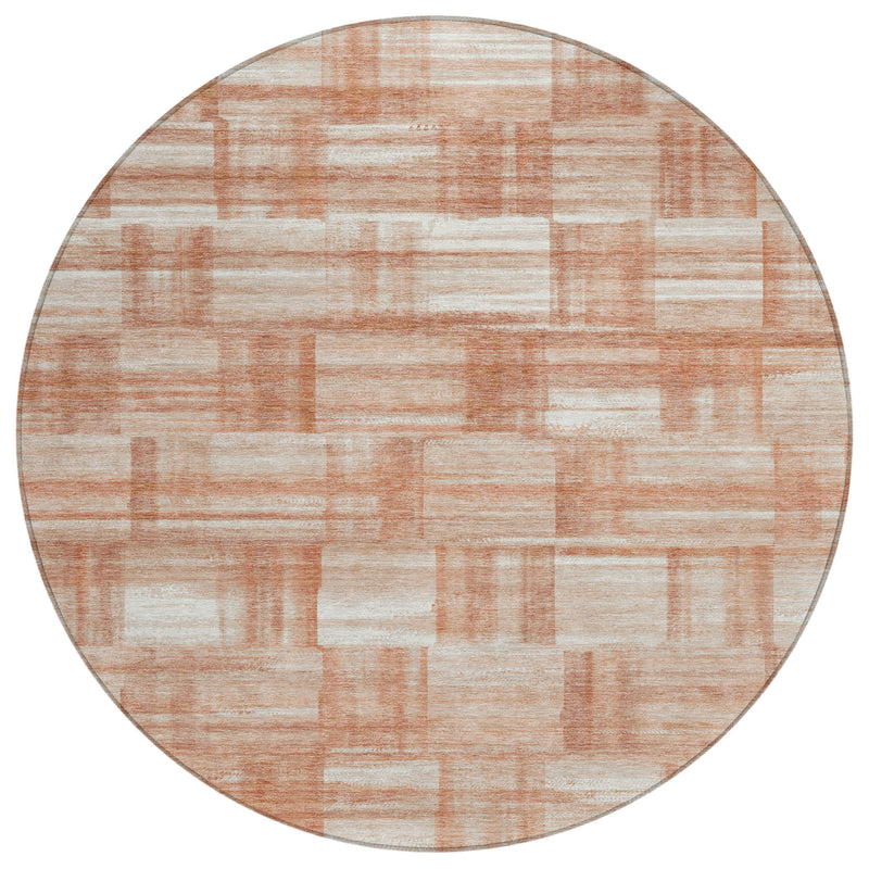 Round area rug with cream and salmon patchwork rectangles, muted copper stripe details