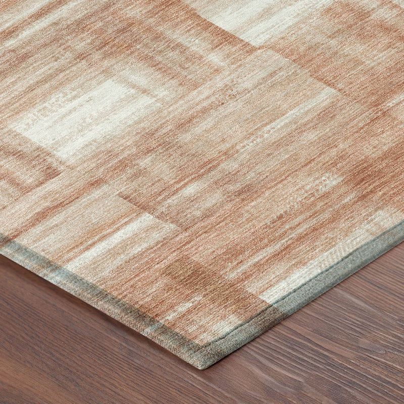 Corner view of round area rug with cream and salmon rectangle blocks and low-pile border