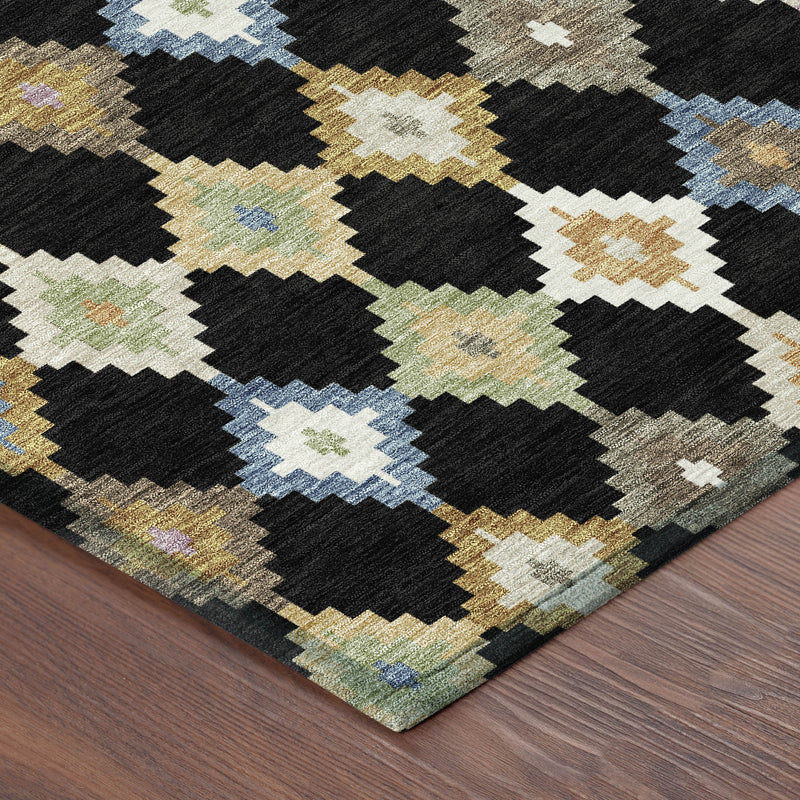 Corner of black and beige Aztec area rug with blue, gold, and pastel diamond motifs.