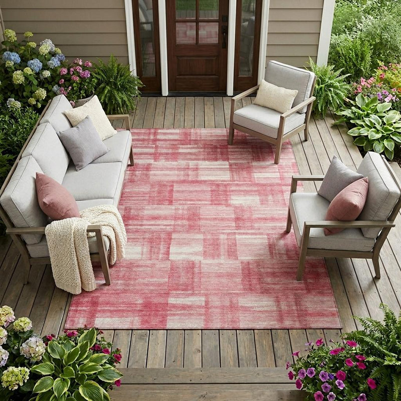 Pink and ivory striped area rug on an outdoor deck with patio seating nearby.