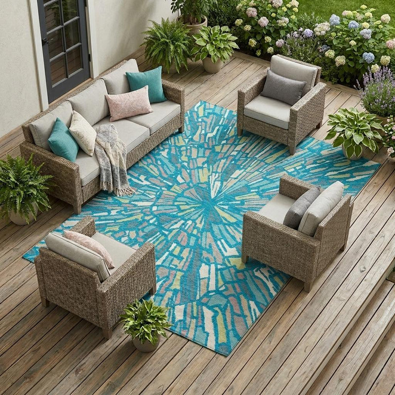 Teal blue abstract indoor outdoor area rug with burst design in patio seating area