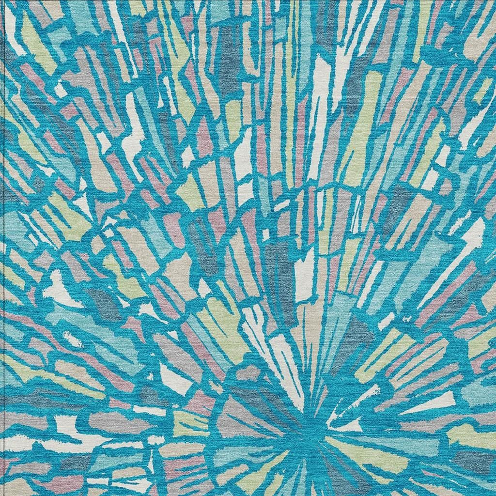 Teal blue abstract area rug with radial sunburst pattern and cream streaks, close-up