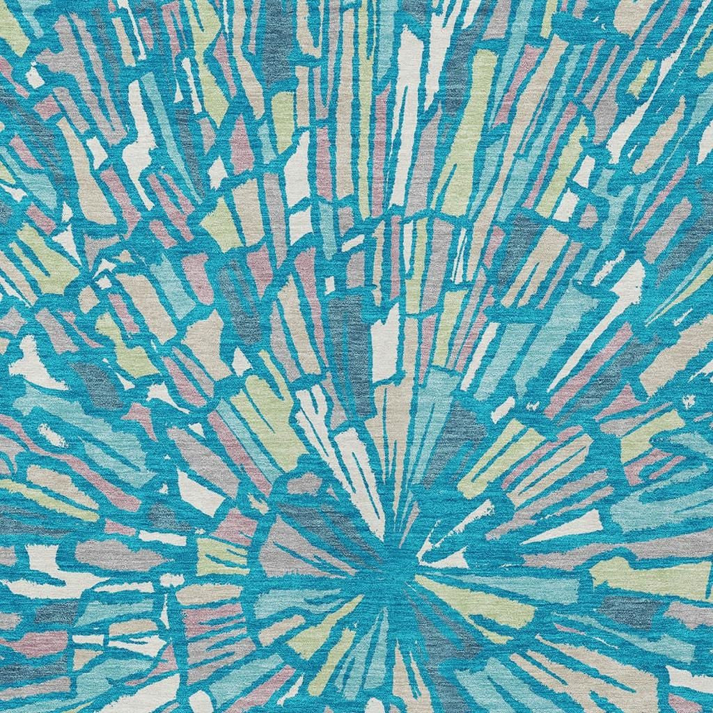 Teal blue abstract area rug close-up with central sunburst and streaked lines