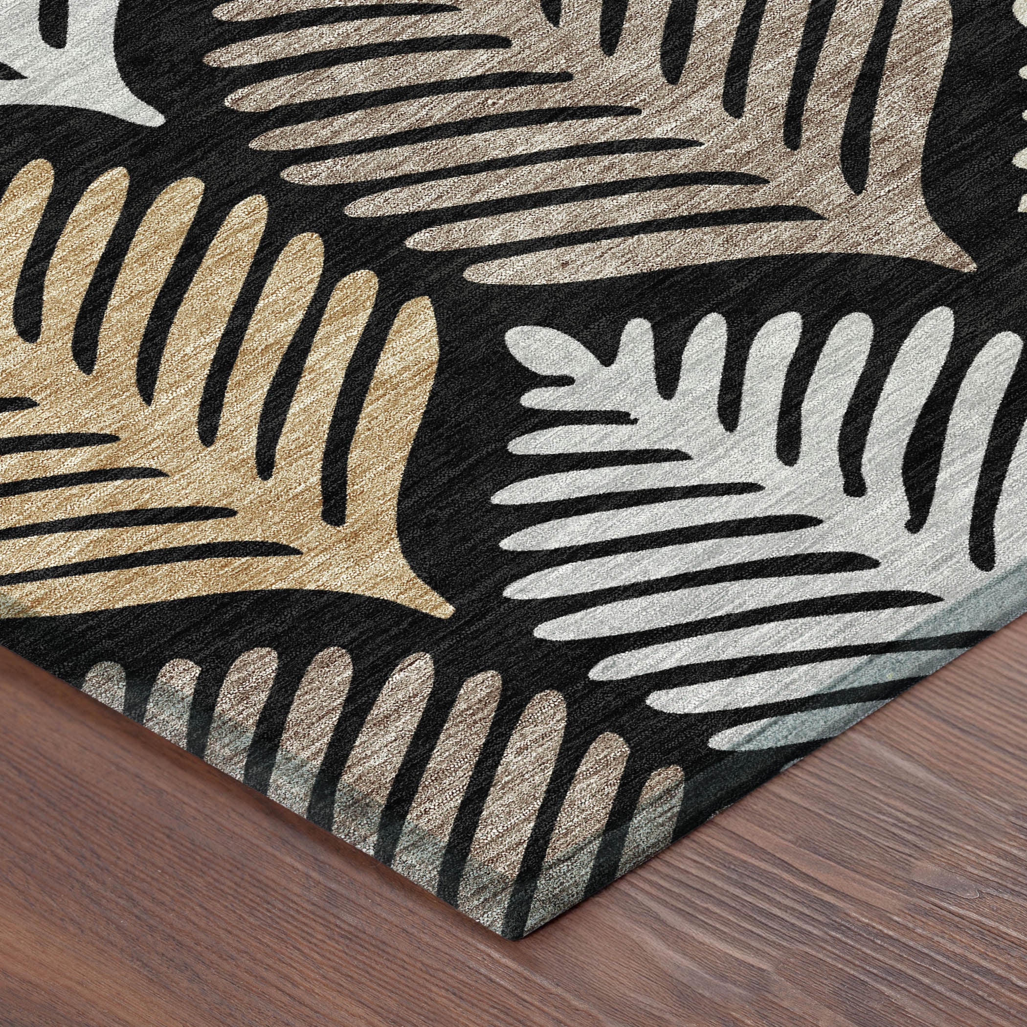 Black and gray leaf-pattern area rug corner with beige and gold accents.
