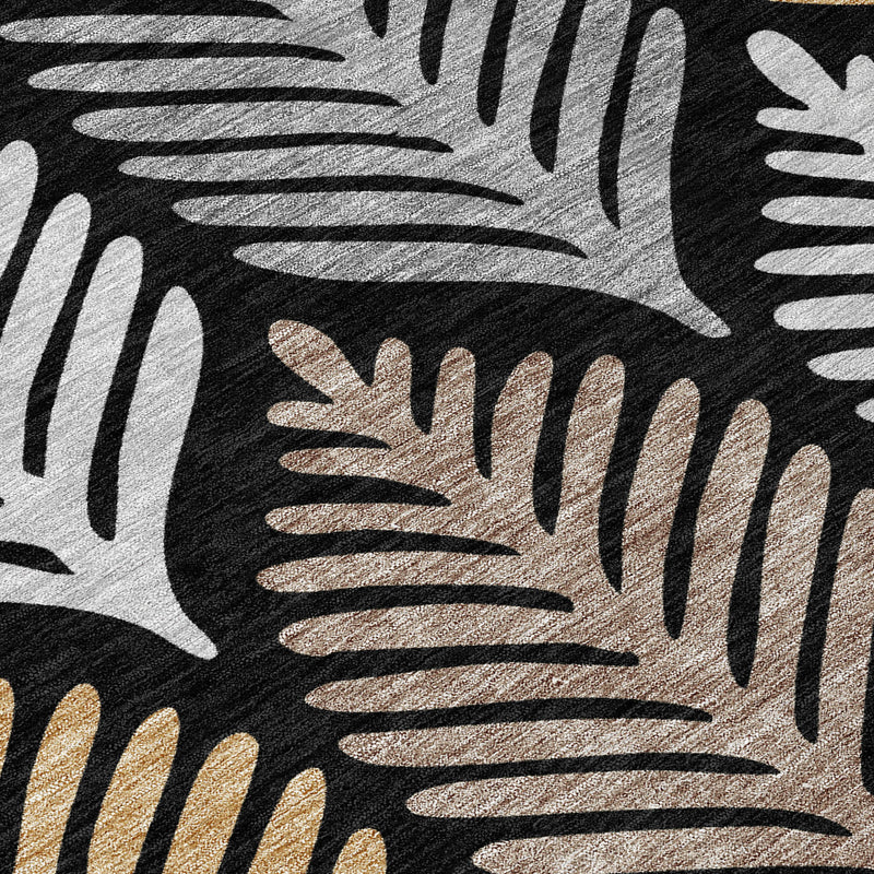 Close-up leaf motif on black and gray area rug with beige and gold detailing.