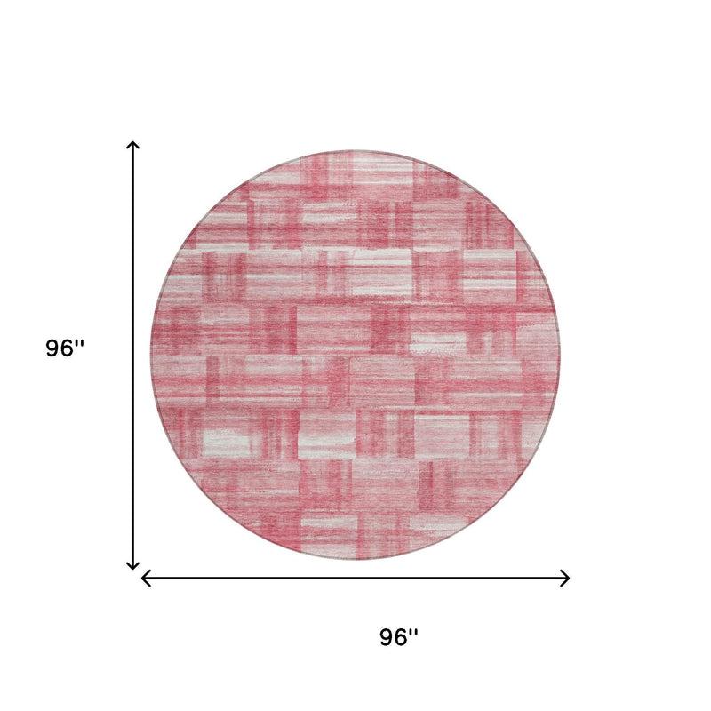 Round pink and ivory area rug with distressed grid patchwork pattern