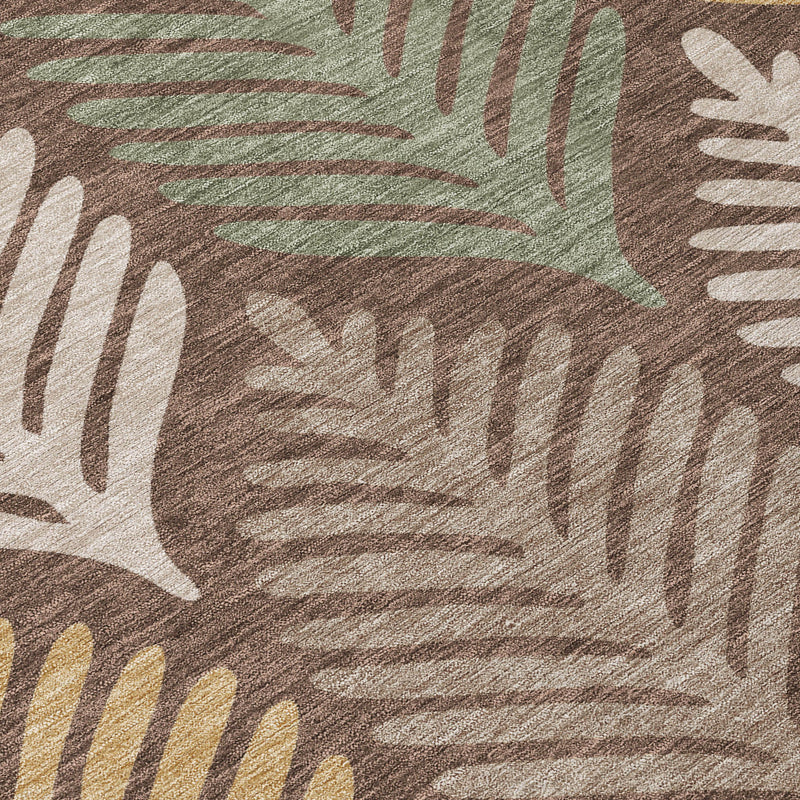 Brown indoor outdoor area rug close-up with multicolor leaf silhouettes