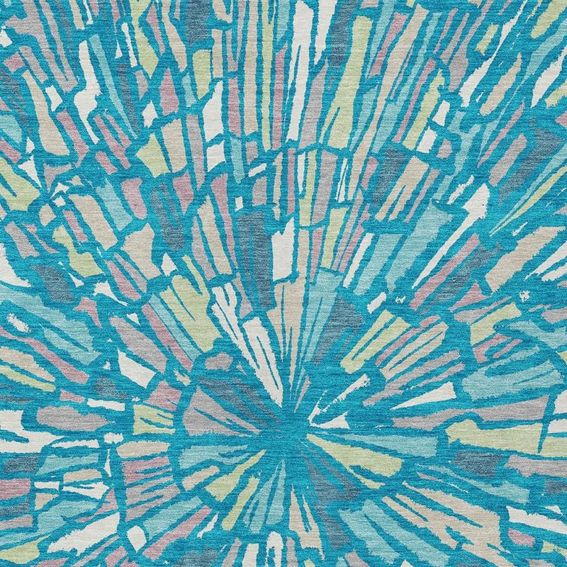 Close-up of abstract area rug with teal-blue burst design and white linear accents