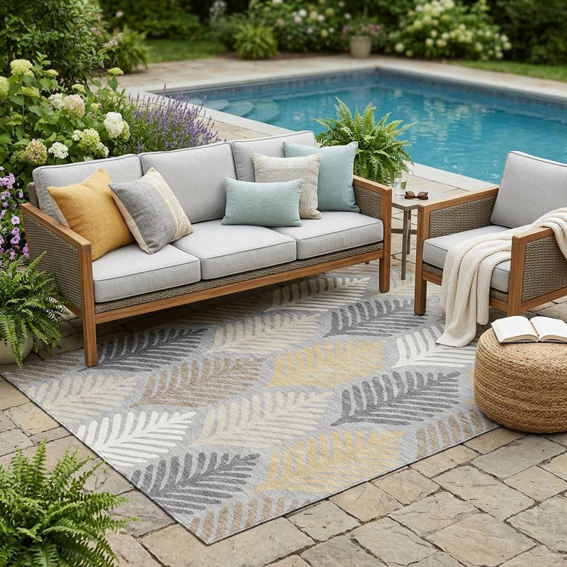 Outdoor area rug with gray, beige, and light blue leaf pattern under patio seating
