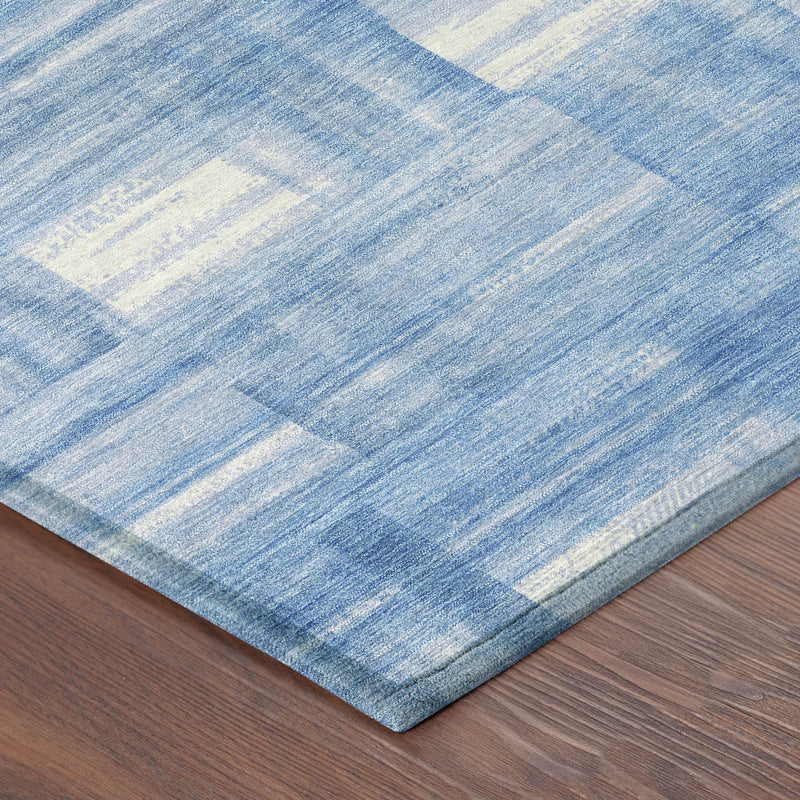 Denim blue and ivory striped washable rug, folded corner close-up