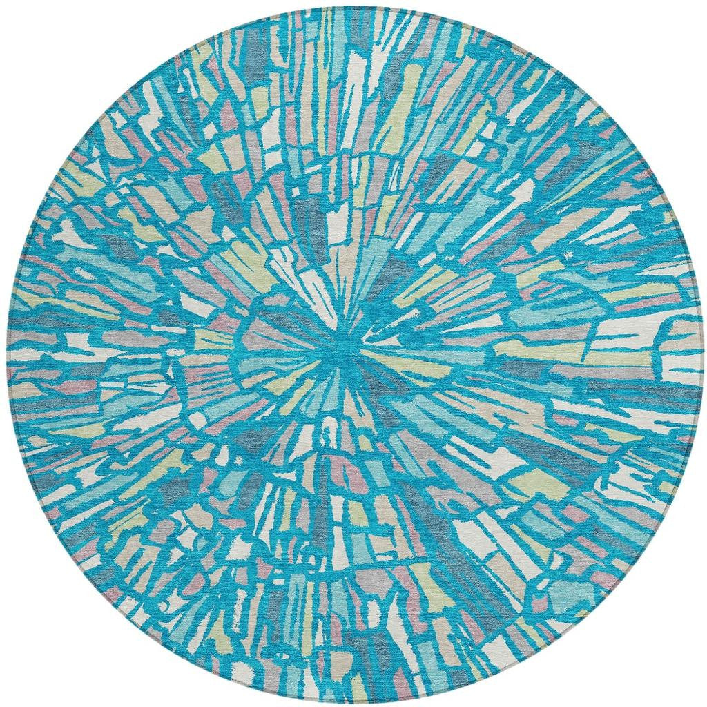Round abstract area rug with teal, blue, and green burst pattern and cream accents.