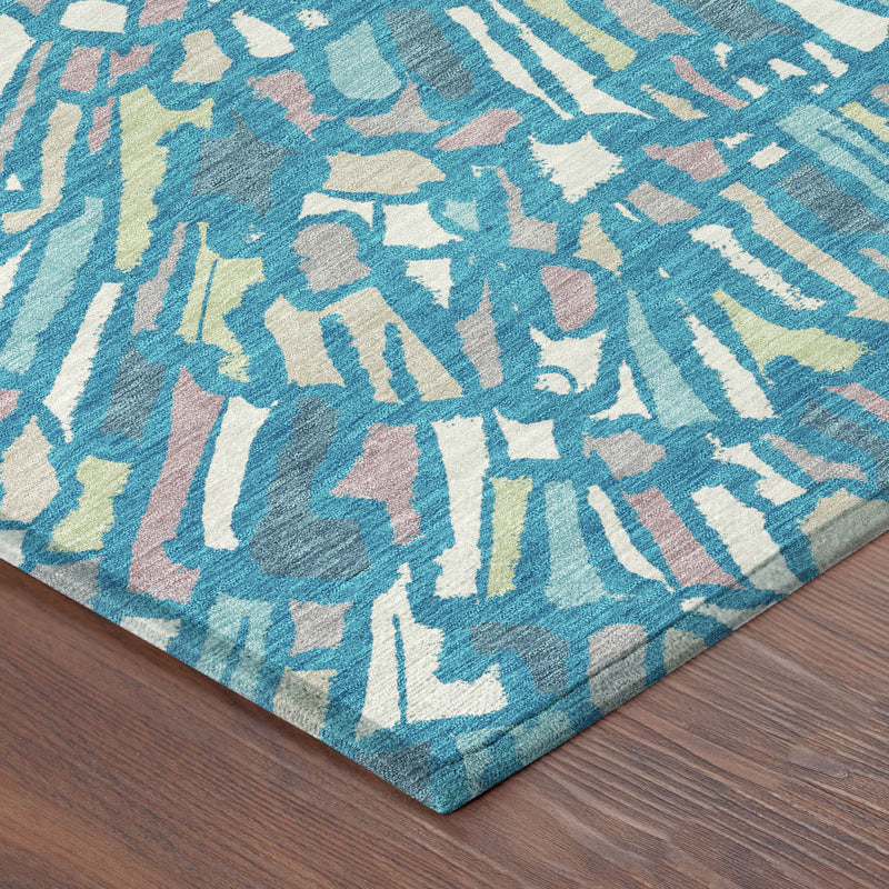 Round rug corner view, teal and blue abstract rays with cream and green highlights.