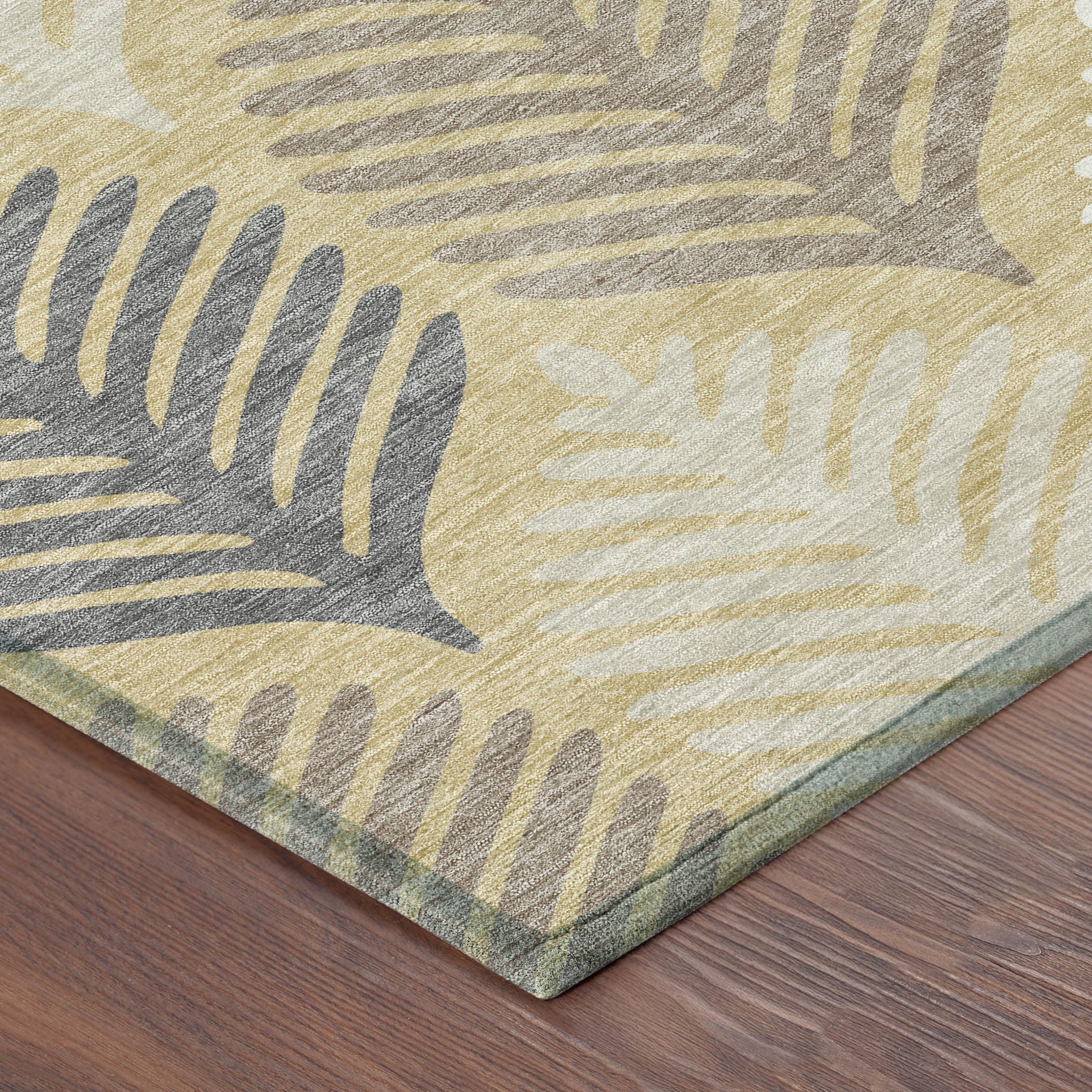 Indoor outdoor area rug corner with ivory and gold leaf motifs and gray edges