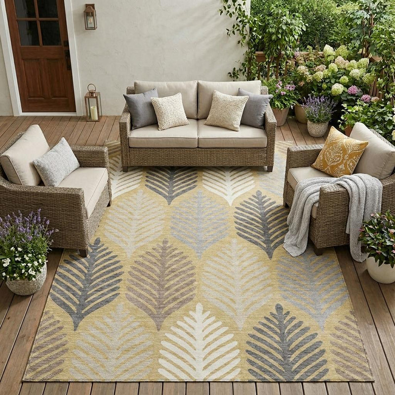 Indoor outdoor area rug with ivory, gold, and gray leaf design on patio flooring