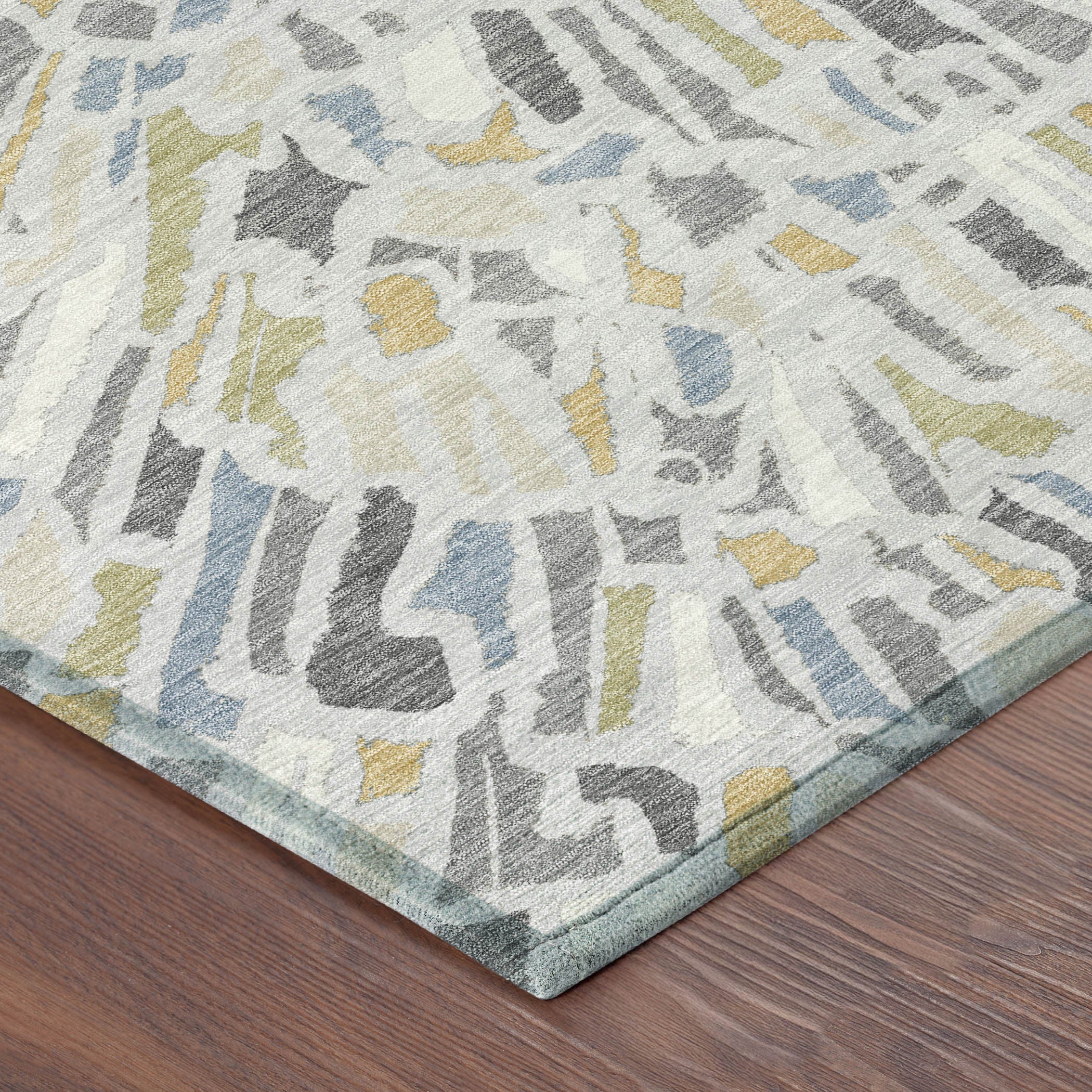 Abstract rug corner with silver-gray, blue, and yellow sunburst pattern; textured weave