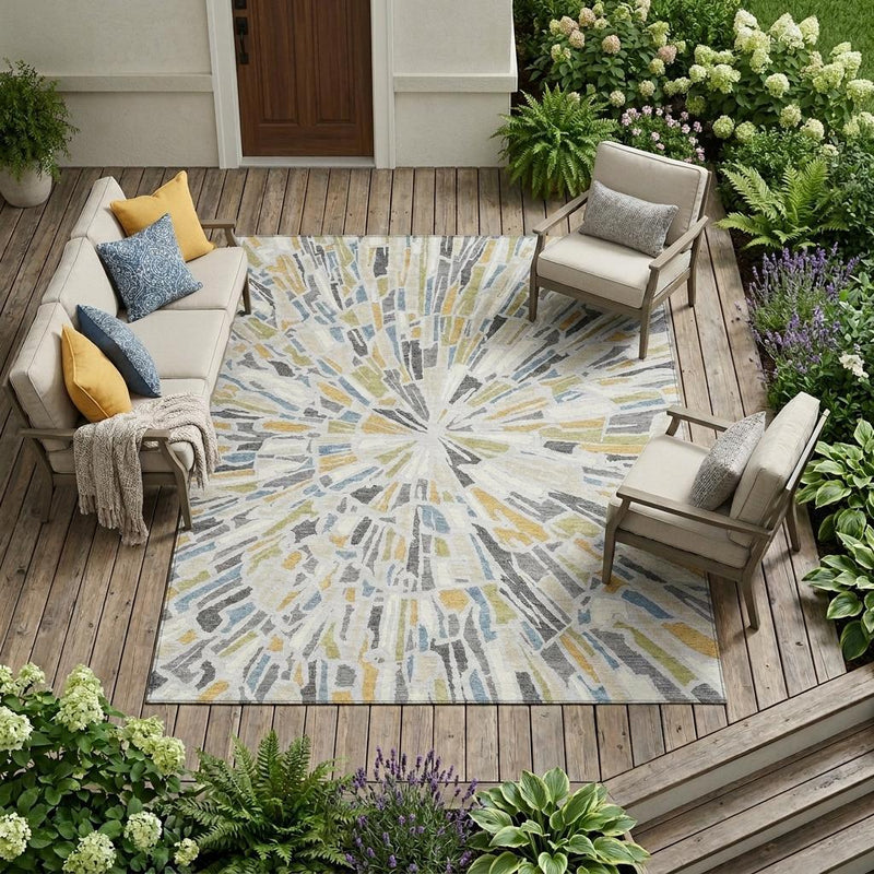 Abstract area rug with silver, gray, and blue sunburst pattern for indoor/outdoor spaces