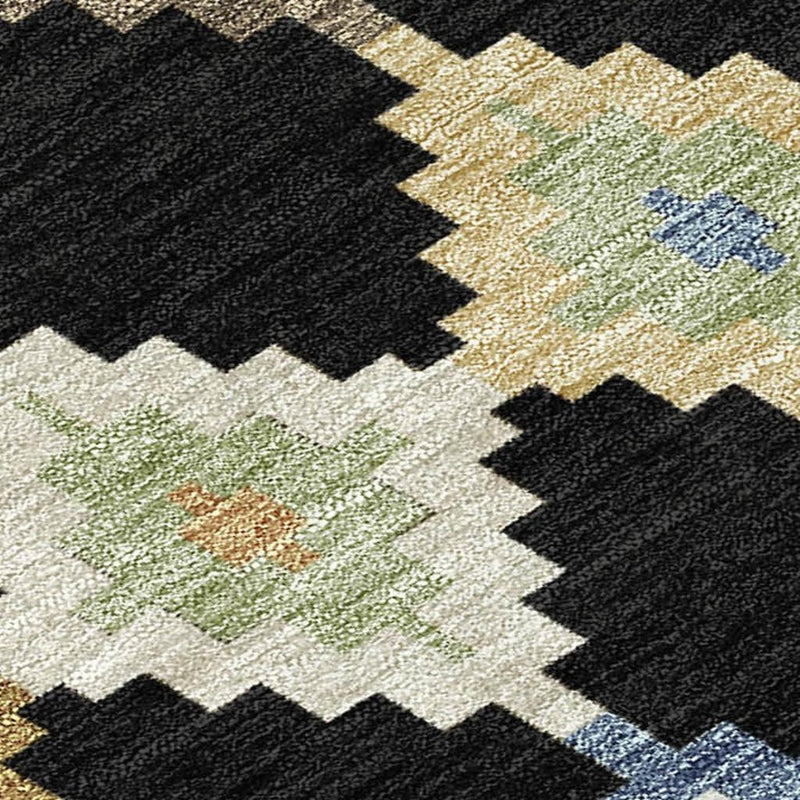 Textured close-up round area rug with black, beige, and green-blue Aztec diamonds