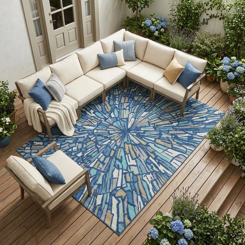 Indoor outdoor area rug with abstract navy and teal starburst pattern