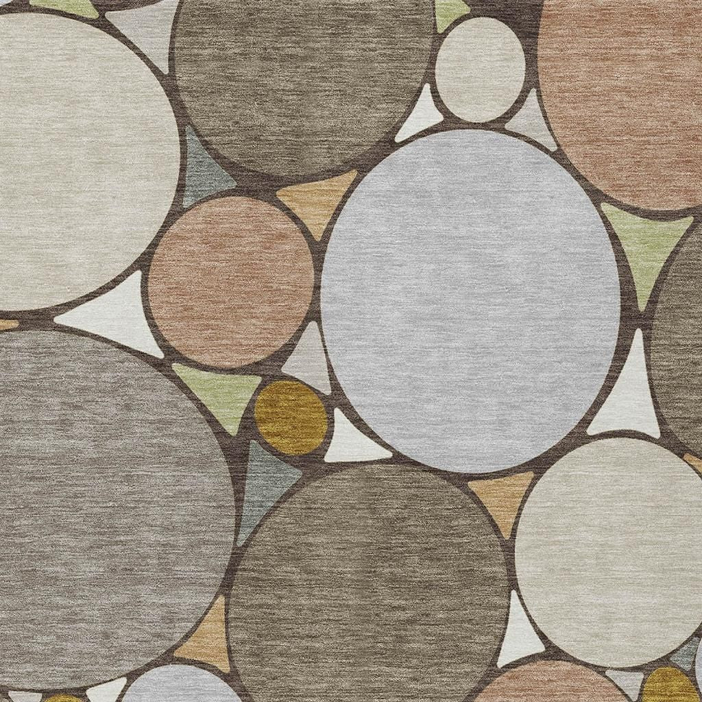 Geometric area rug close-up with large gray and cream circles, tan and mustard accents