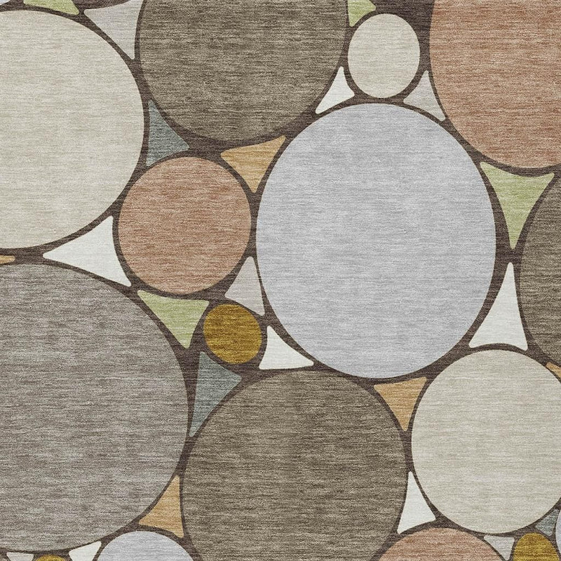 Geometric area rug close-up with large gray and cream circles, tan and mustard accents