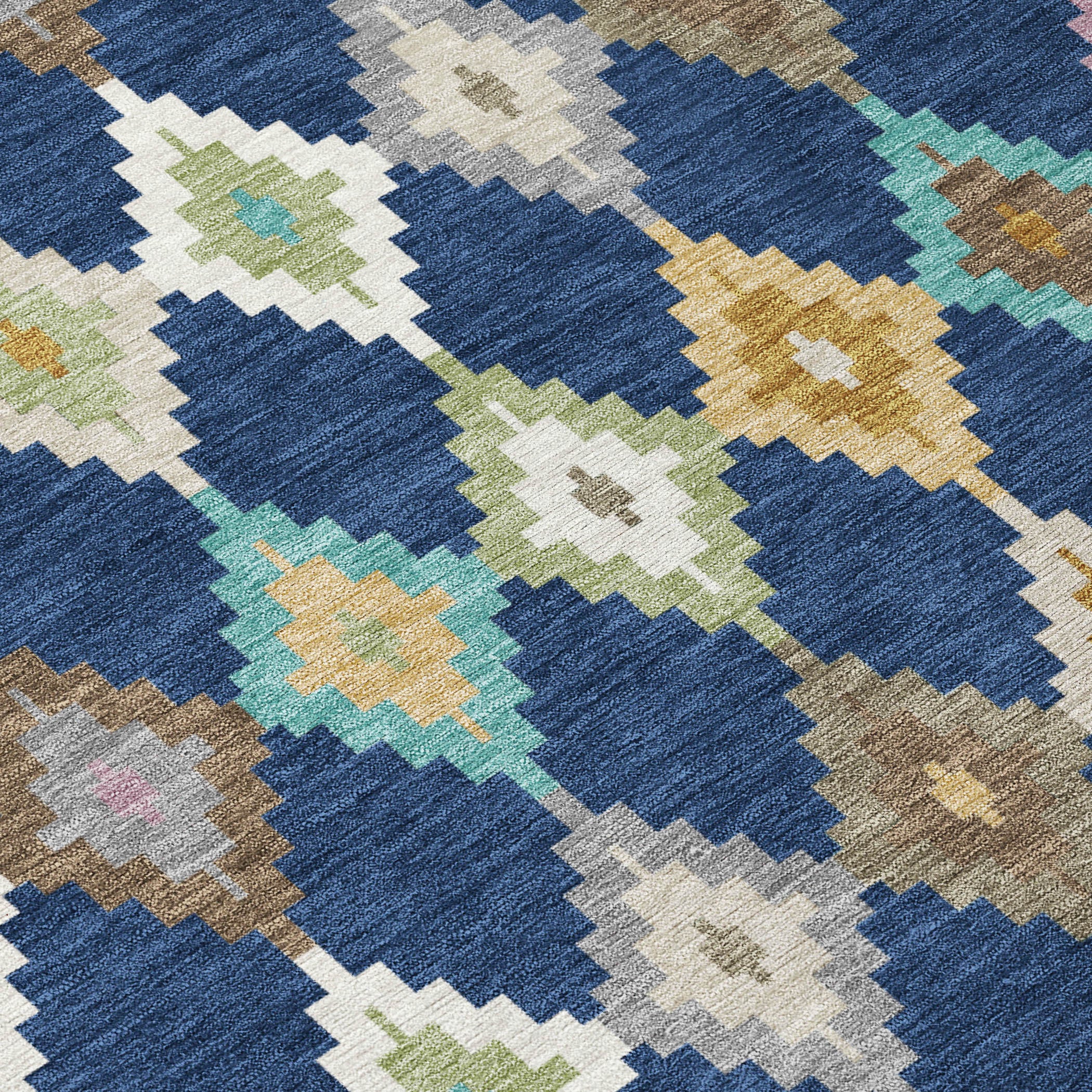 Close-up of blue area rug fabric with geometric diamonds in teal, gold, and cream.