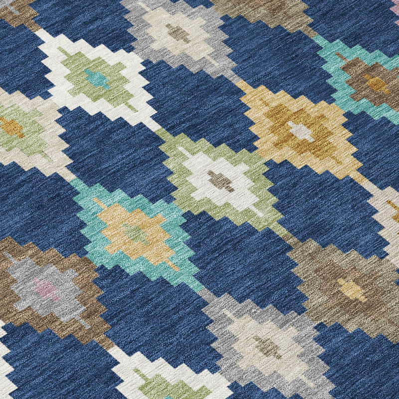 Close-up of blue area rug fabric with geometric diamonds in teal, gold, and cream.