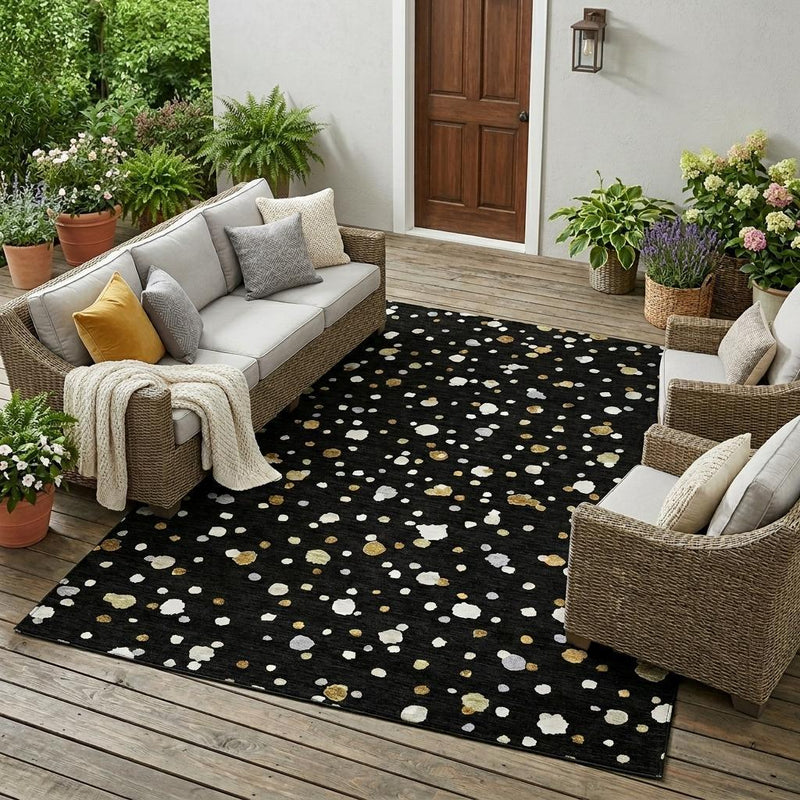 Black geometric speckled area rug with white and gold accents on wood floor