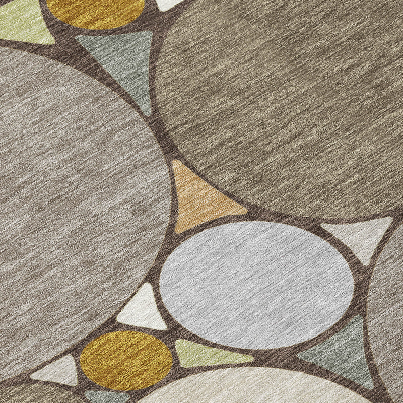 Close-up of geometric circles on gray and taupe area rug with mustard accents