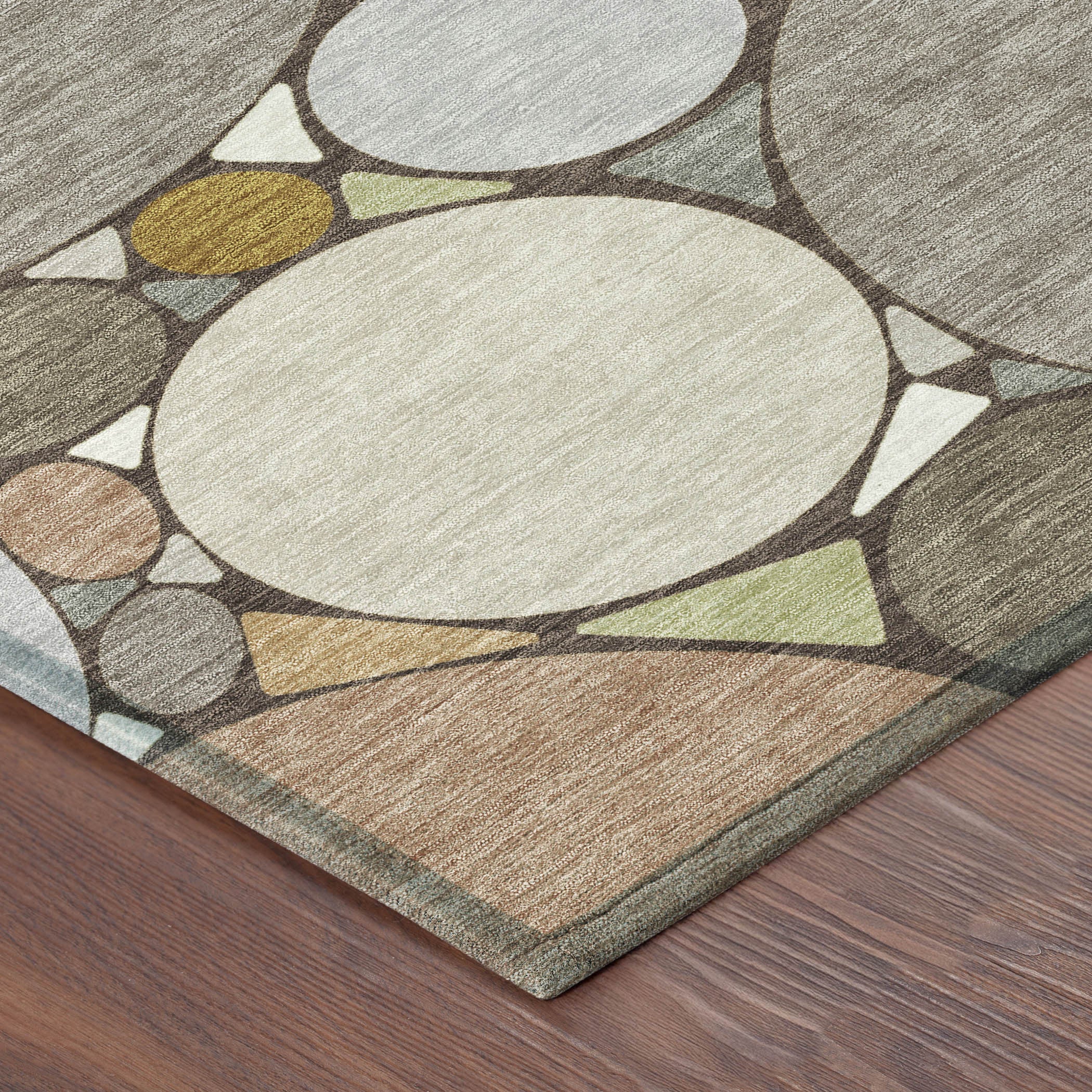 Corner view of geometric circle area rug in taupe, beige, gray, and cream