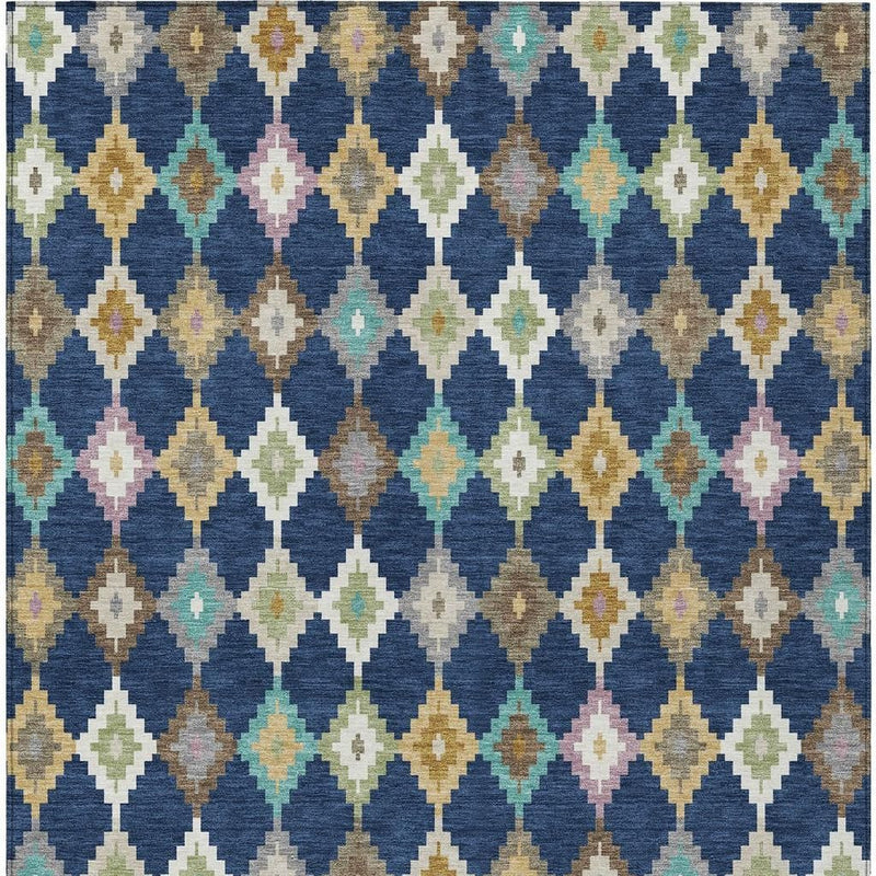 Blue aztec area rug with repeating diamond motifs in cream, teal, green, tan, and pink