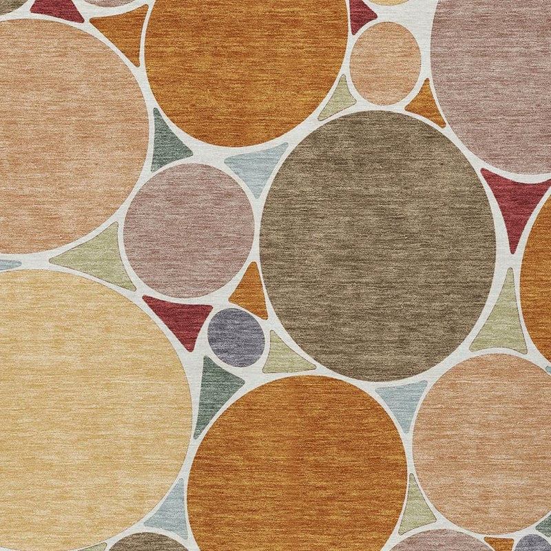 Geometric rug close-up with textured circles in orange, gray, tan, and muted greens