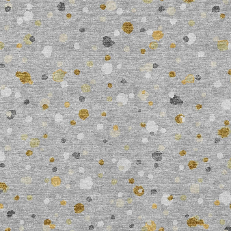 Gray area rug with scattered geometric speckles in gold, white, and dark gray
