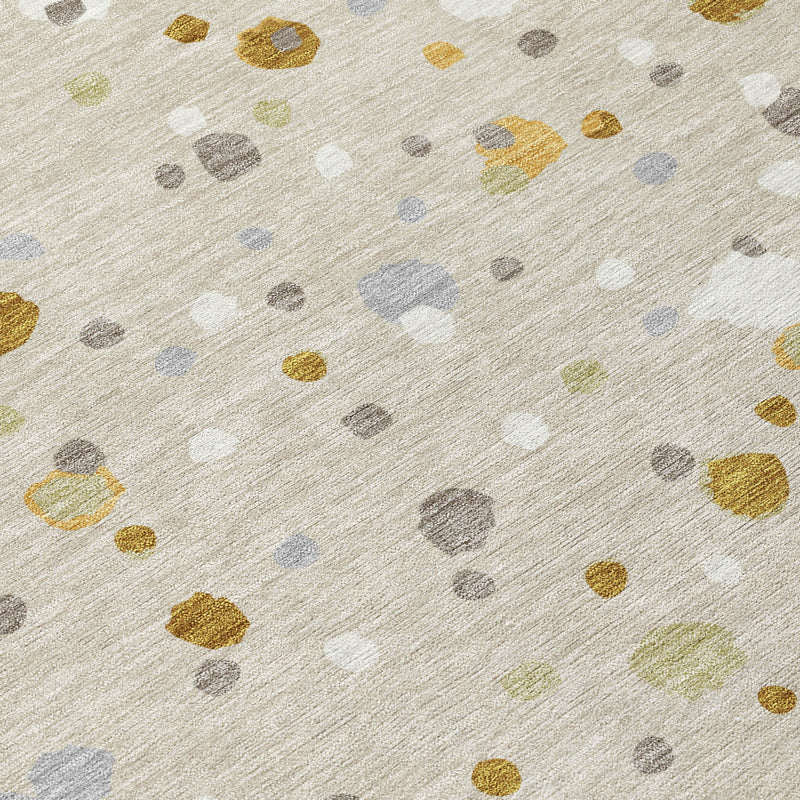 Beige area rug with scattered gold and gray geometric speckles, fabric texture visible