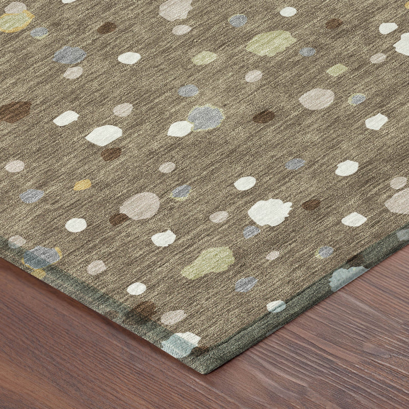 Brown area rug corner with scattered white, beige, blue and yellow speckles; flat woven