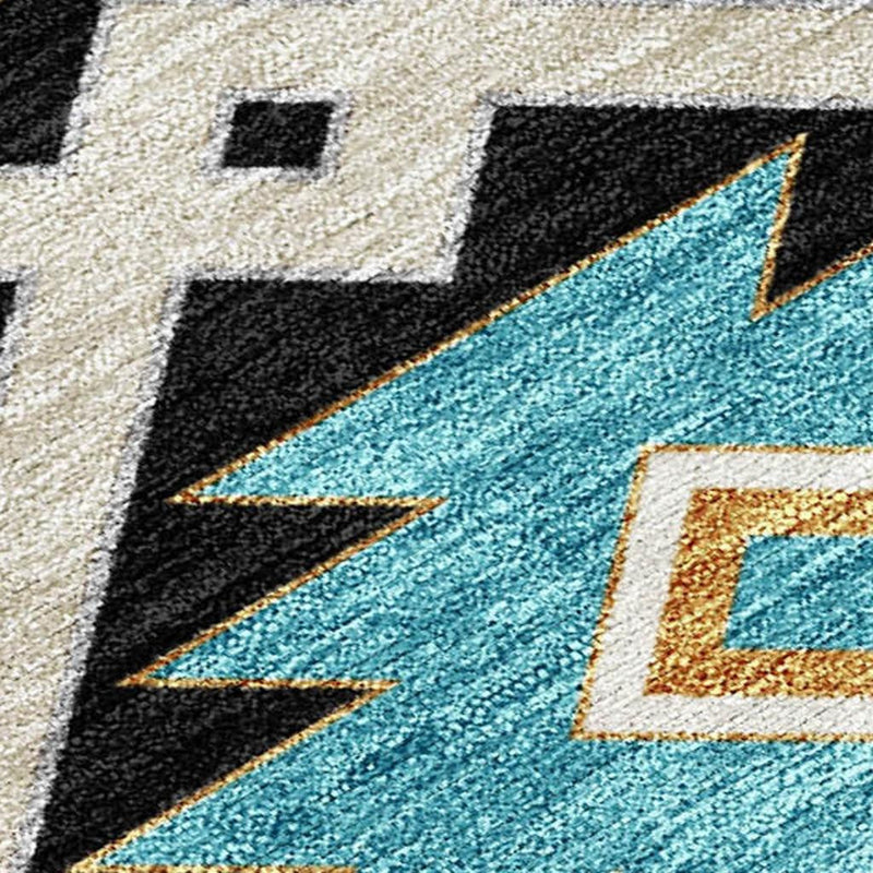 Rug close-up showing textured cream background with black blocks and turquoise starburst