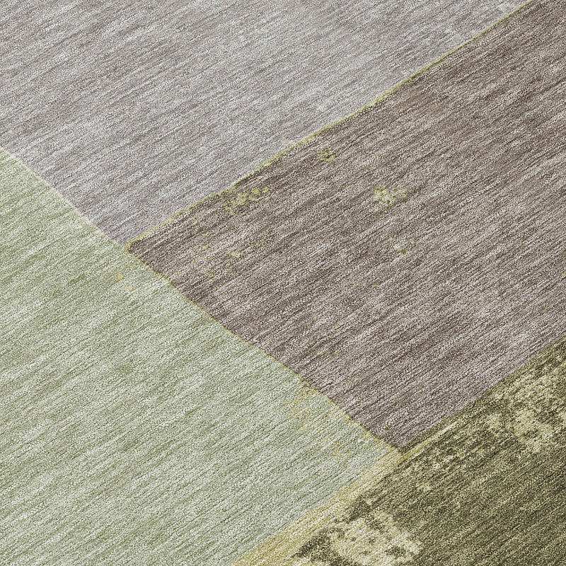 Textured close-up of an olive and fern green geometric rug with distressed finish.