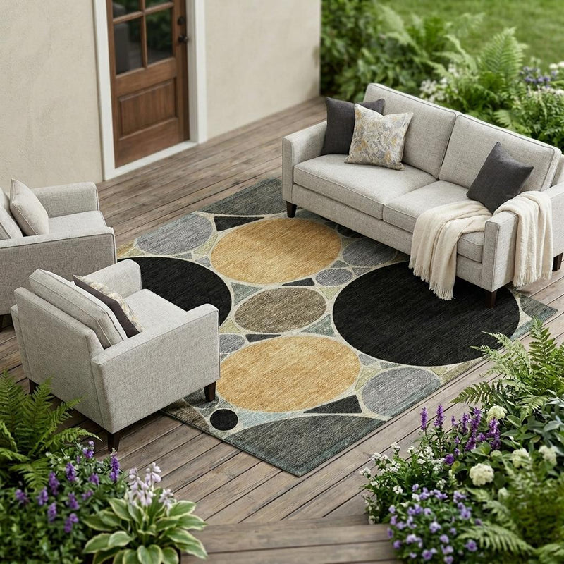 Geometric area rug with circular pattern in gray, black, tan, and gold, outdoor setting