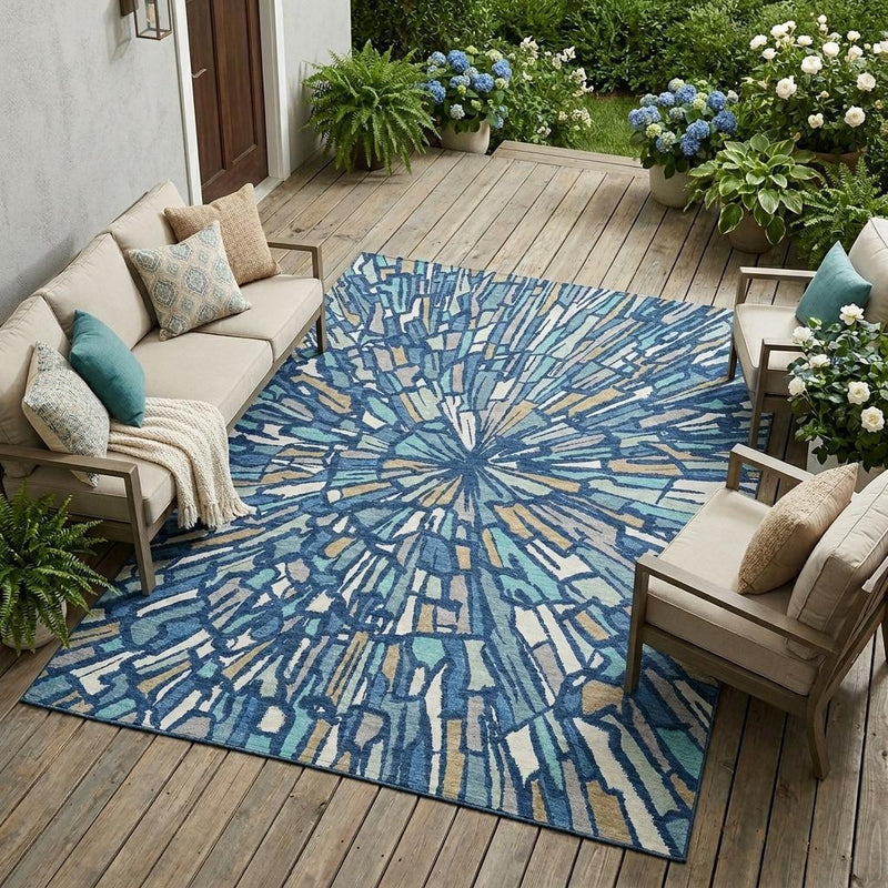 Indoor outdoor area rug with abstract navy and teal burst pattern on flat weave