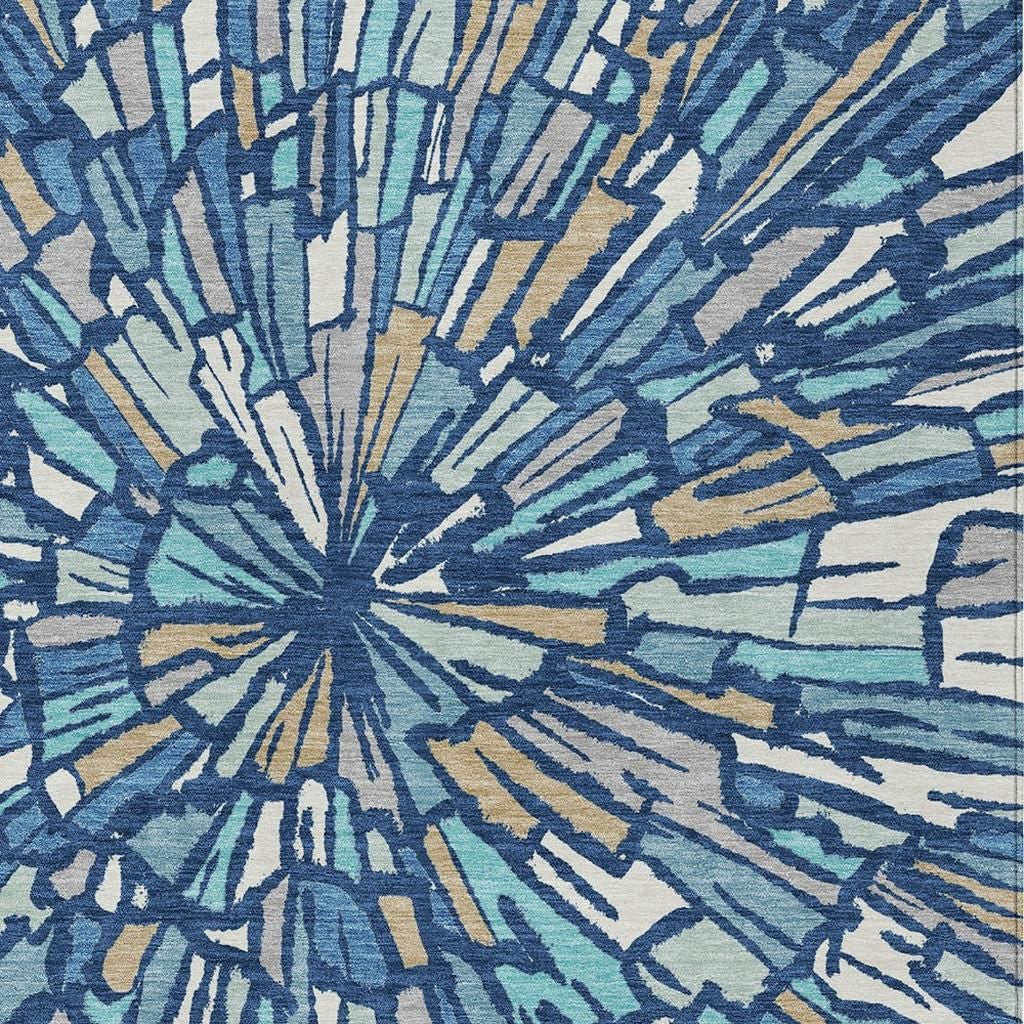 Close-up of abstract sunburst area rug pattern in navy, teal, and tan highlights