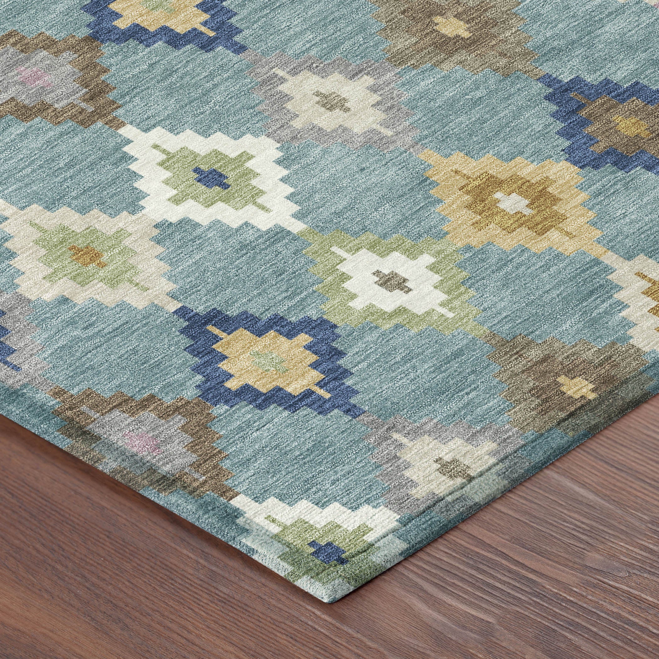 Teal blue rug corner with multicolor diamond and cross-pattern accents