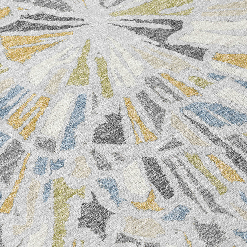 Close-up of abstract area rug rays in light cream, gray, blue, and yellow with textured weave.