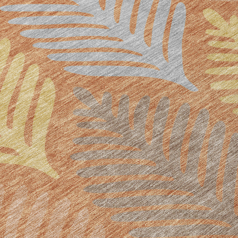 Close-up of orange and copper area rug with white and gray leaf pattern